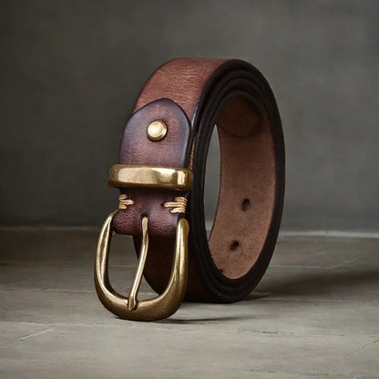 Men's black cattlehide leather jeans belt with a copper pin buckle shown on a flat surface.