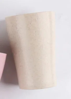 A cylindrical wheat straw plastic bathroom cup in a Nordic colour, holding toothbrushes.
