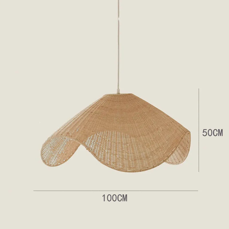 Handmade woven rattan and willow chandelier with warm LED light in a rustic setting.