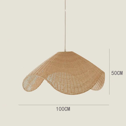 Handmade woven rattan and willow chandelier with warm LED light in a rustic setting.