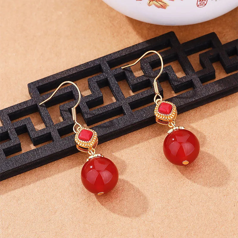 Geometric silver-toned earrings with round red agate beads and small inlaid jasper stone accents.