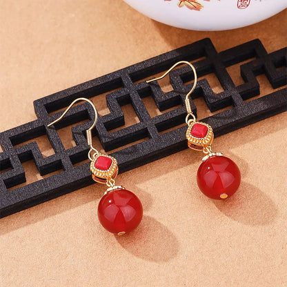 Geometric silver-toned earrings with round red agate beads and small inlaid jasper stone accents.