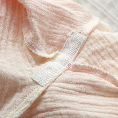 Women's pink pure cotton gauze lace-up top and trousers homewear set laid flat.