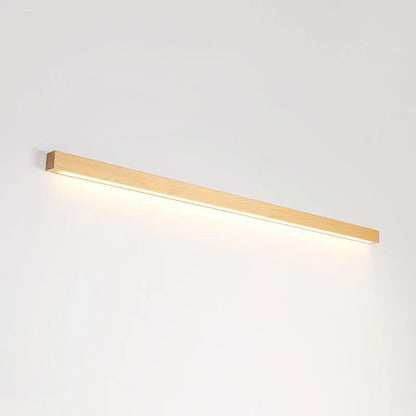 Slim walnut-coloured wooden strip wall lamp with acrylic light diffuser mounted on a plain wall.