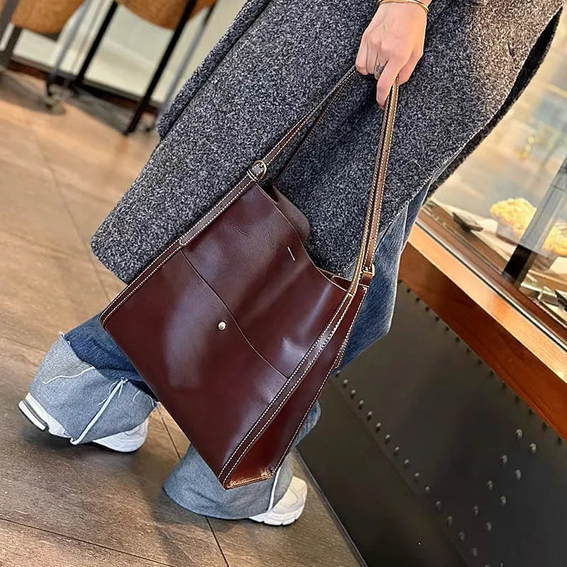 Genuine leather women's tote bag in a square shape with multiple internal pockets, shown in sunset yellow.