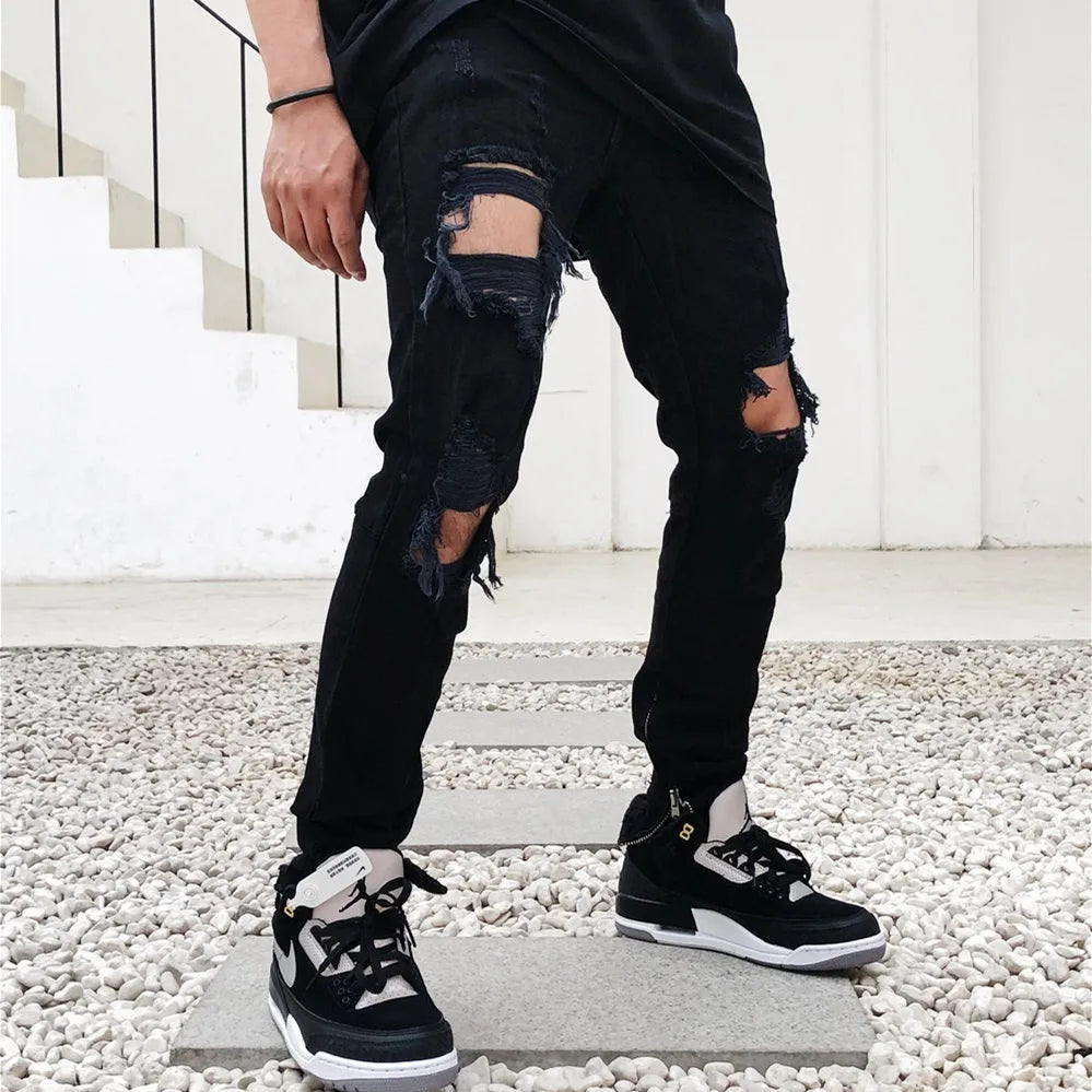 Men's black torn jeans in cotton elastic denim with medium to low waist, zip fly, and raw edges, sizes M to 2XL