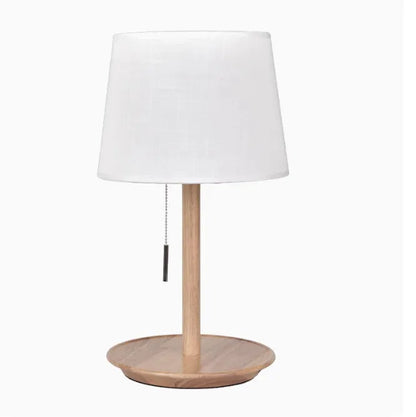 Walnut coloured solid wood bedside lamp with white fabric shade and cable switch.