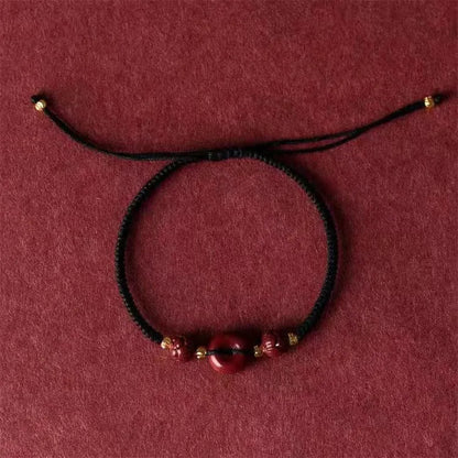 Cinnabar heart-shaped bracelet with safety buckle closure and adjustable coloured rope in traditional Chinese design