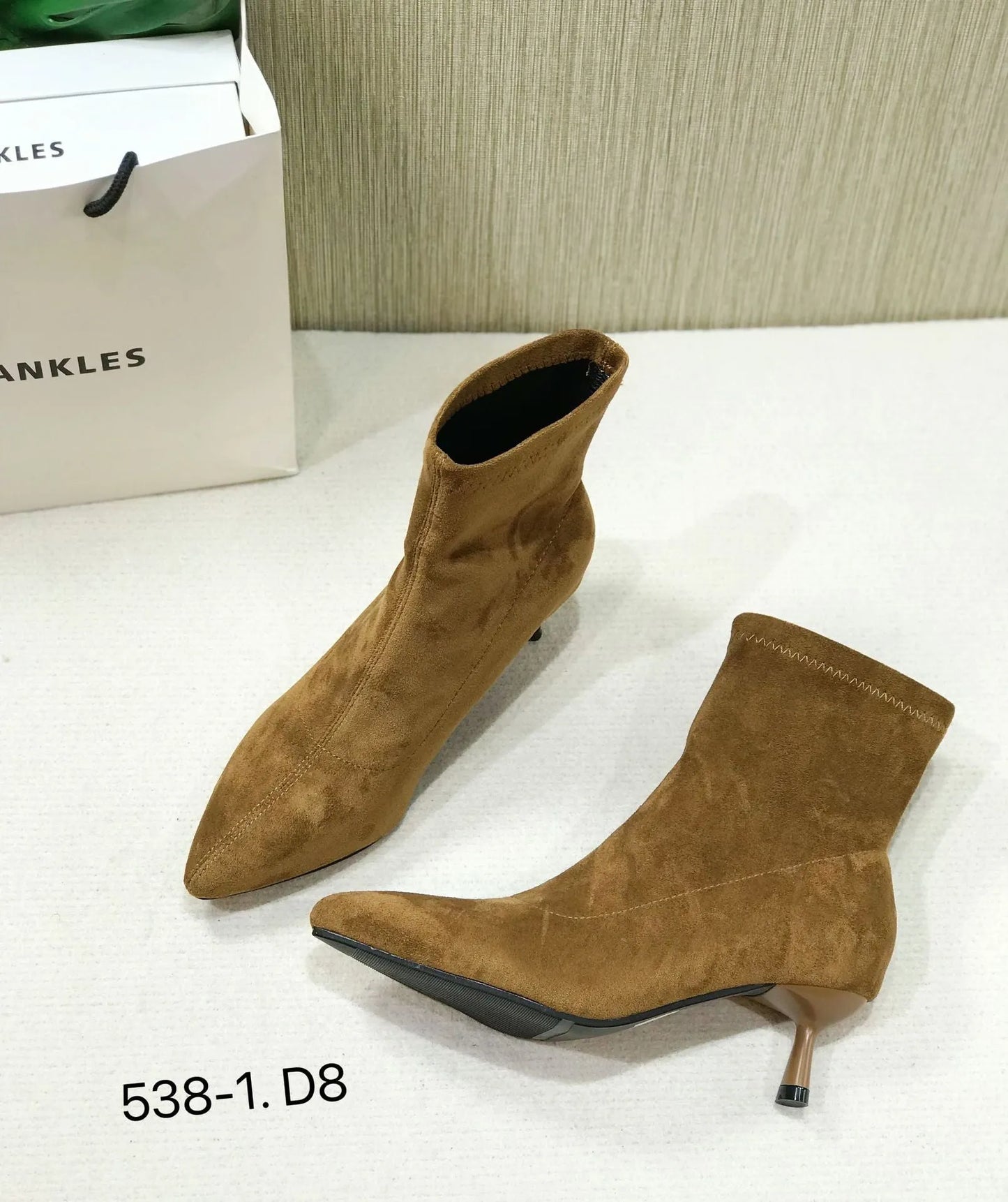 Women's black pointed toe ankle boots with a stiletto heel on a neutral background