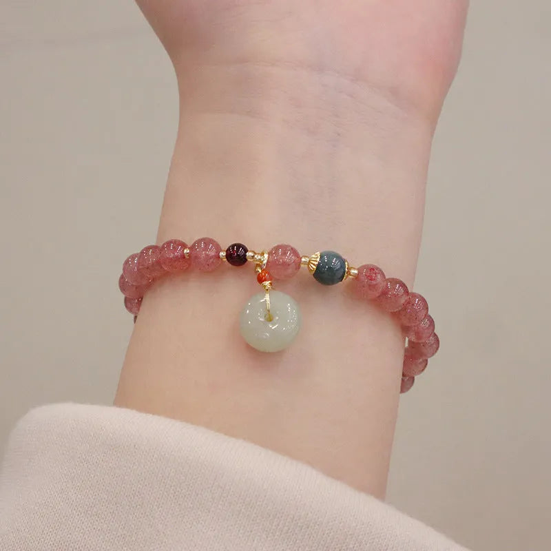 Natural strawberry quartz geometric bracelet with a small purse charm and silver safety buckle closure.