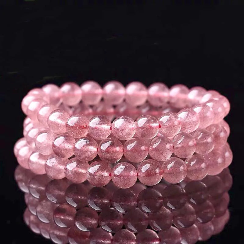 A women's bracelet made of polished strawberry quartz crystal beads in one of three size options.