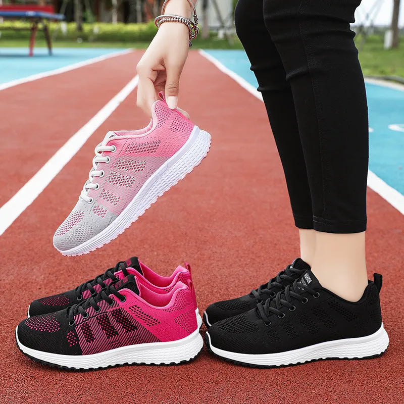 Women's flyknit running shoes in grey pink with soft sole and lace-up front.