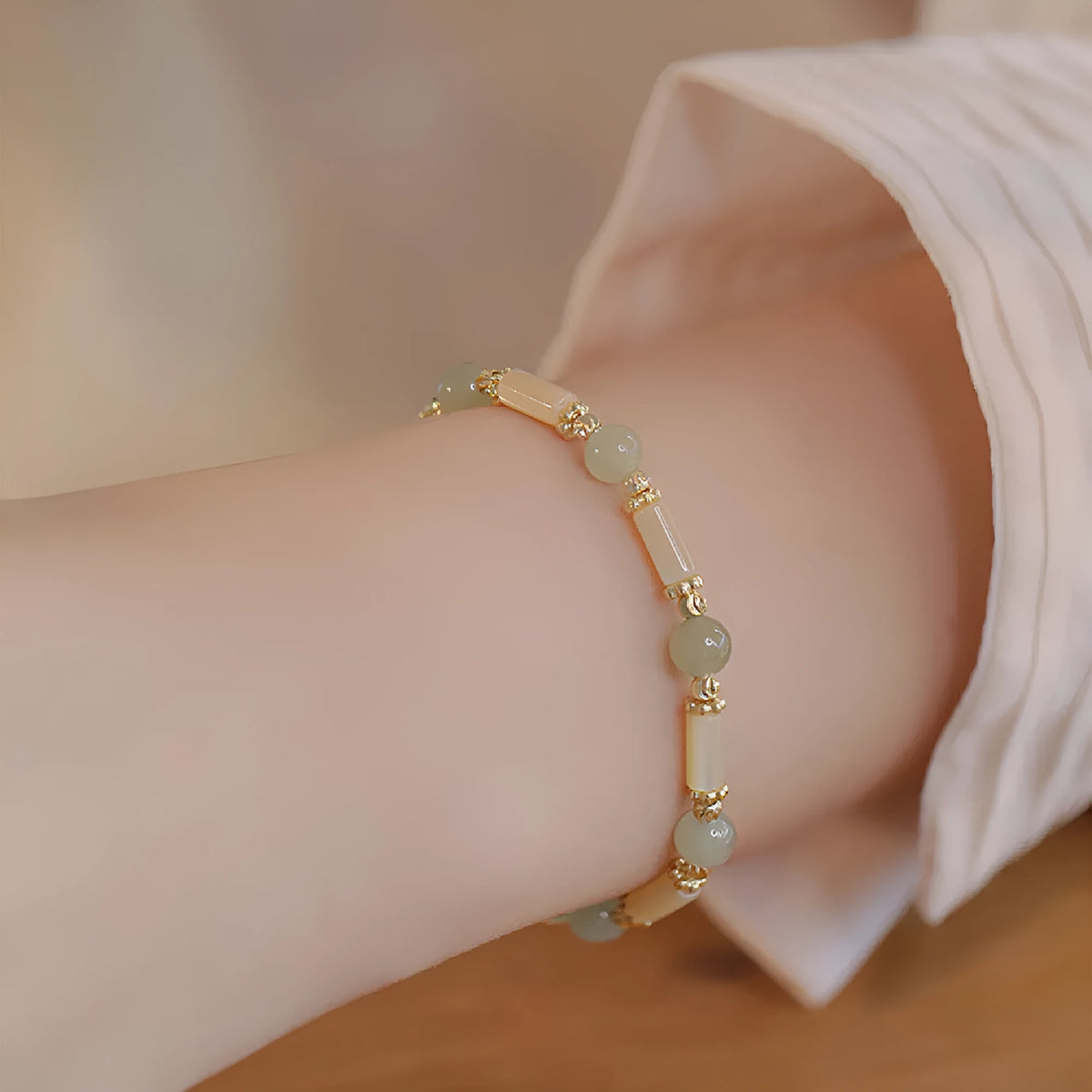 Women's Hetian jade bracelet with bamboo joint design on a white background.