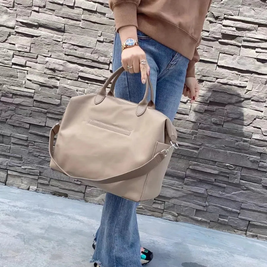 Waterproof nylon shoulder bag with leather accents in black or light khaki, showing 35cm width.