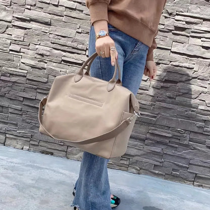Waterproof nylon shoulder bag with leather accents in black or light khaki, showing 35cm width.