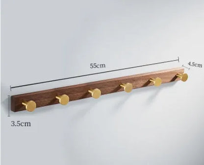 Black walnut wood clothes hooks with brass-finished aluminium frame in a 4-hook wall-mounted style