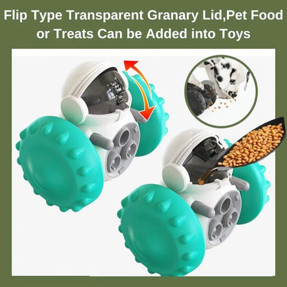 A black, robot-shaped treat dispenser toy for dogs and cats on a wooden floor, showing its size and rolling design.