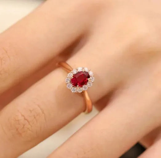 Gold pigeon and floral design women's ring with red gemstone inlay on a silver band.