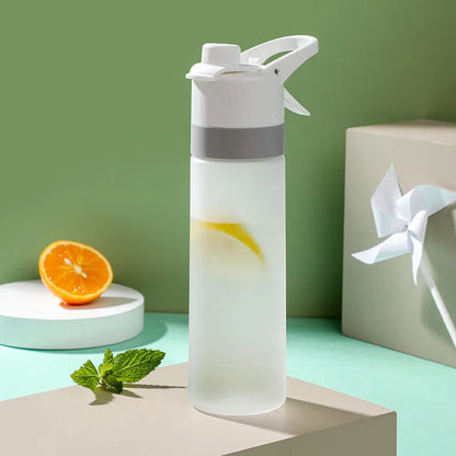 White spray water bottle with black leakproof lid and handle strap on a table