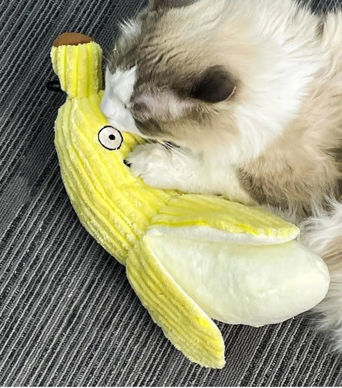 Yellow soft plush banana cat toy with green leaf, measuring 13 inches long, on a plain background.