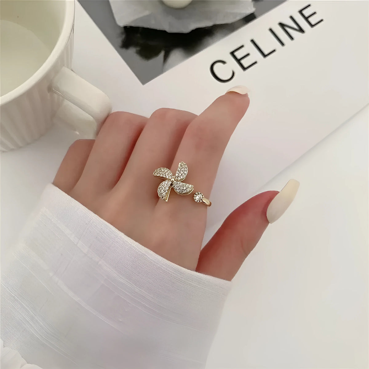 Gold electroplated copper ring with a spinning geometric windmill design on a model's hand.