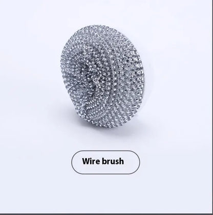 White cordless electric spin scrubber with multiple brush heads on a bathroom tile.