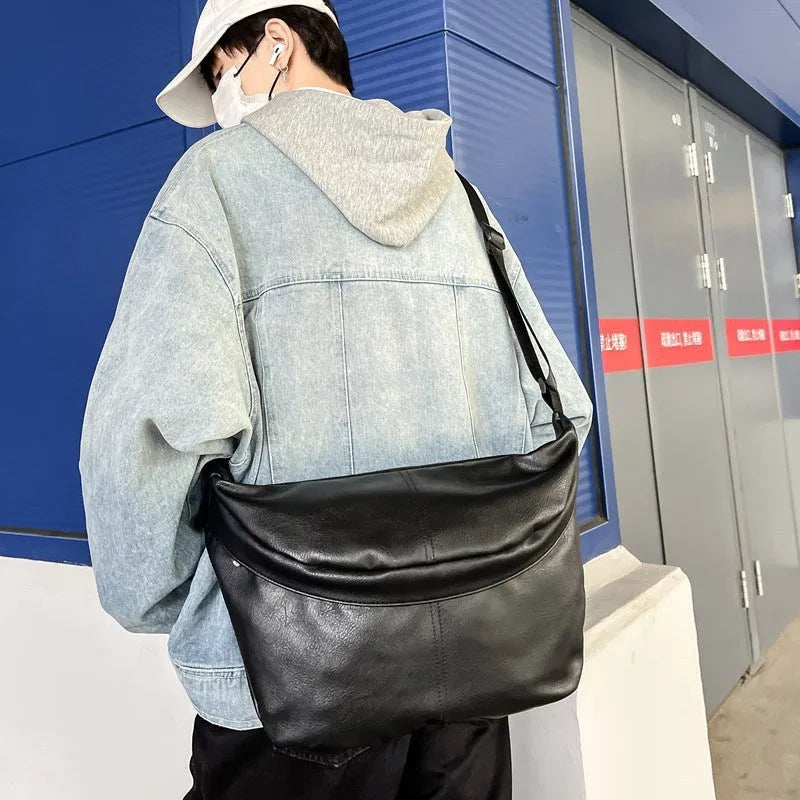 Men's brown vintage PU leather crossbody bag showing large main compartment and slim profile