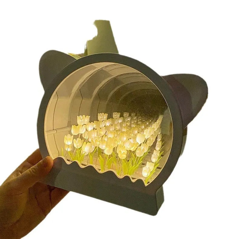 Handmade DIY cat head shaped night lamp with colourful tulip flower sea decoration on a table.