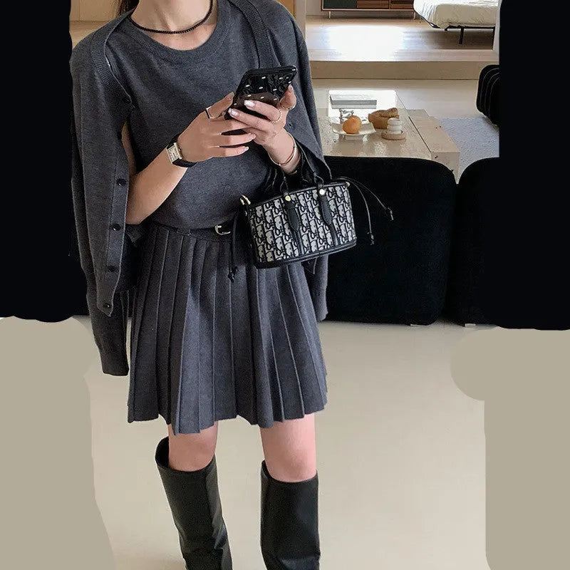 Women's grey knitted vest skirt and cardigan set with 3D pattern, adjustable belt, and pleating detail