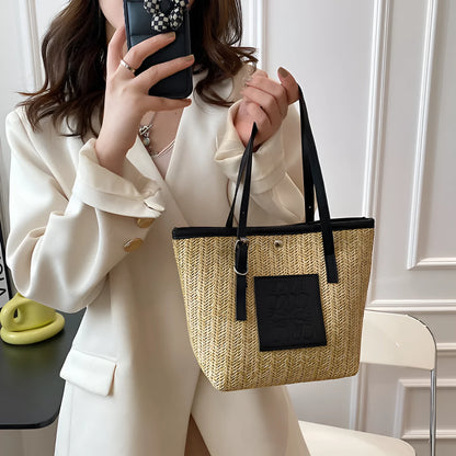 White woven straw women's shoulder bag with a three-dimensional pocket and a black handle.