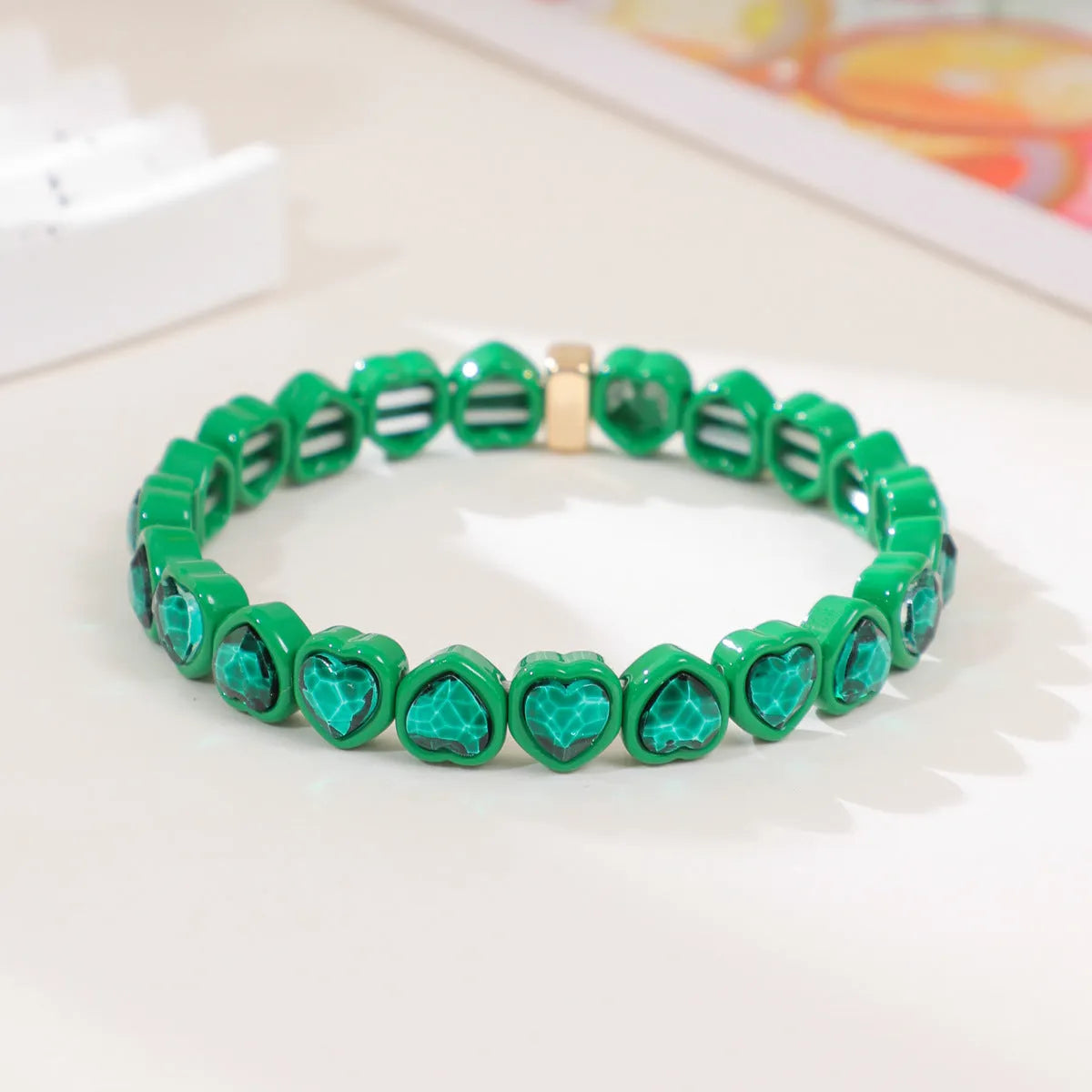Colourful enamel heart shape on a silver-toned alloy stretch bracelet.