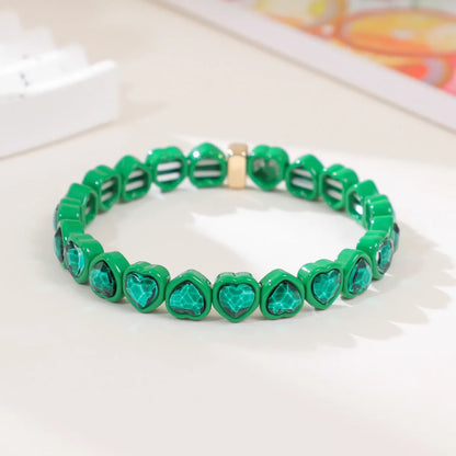 Colourful enamel heart shape on a silver-toned alloy stretch bracelet.