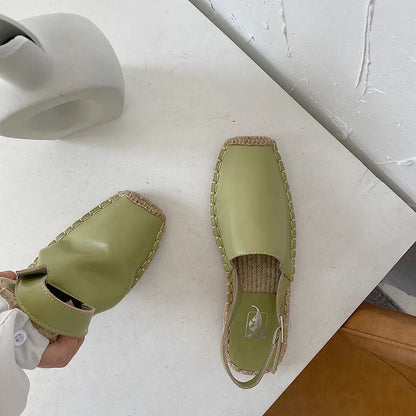 Women's flat canvas fisherman sandals in black, shown from the side on a white background.