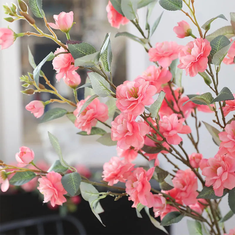 Artificial silk camellia flower in a vase, colours include white, pink, rose pink, and orange coffee.
