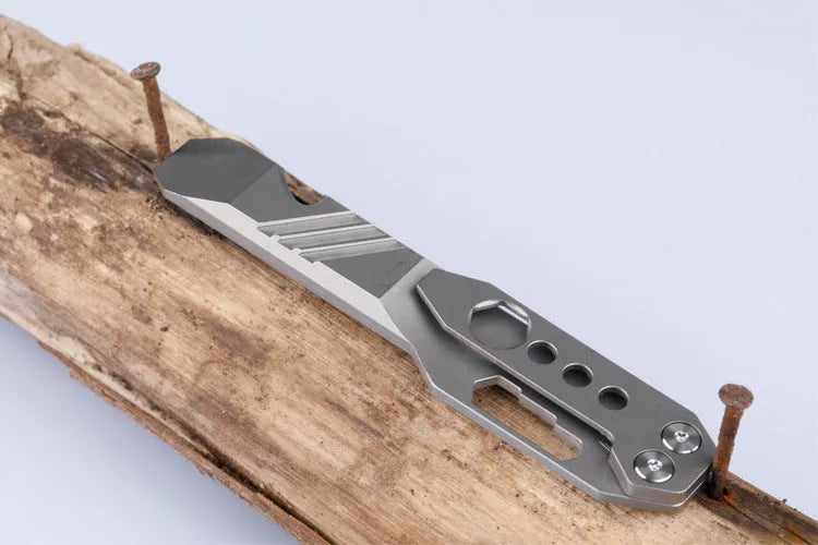 Titanium alloy multi-function crowbar tool with bottle opener on a stone wash finish background.