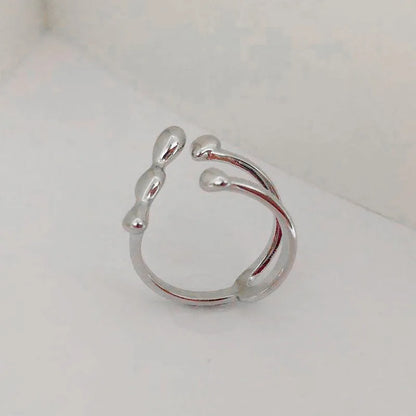 Gold adjustable open ring with spherical details on a woman's hand, showing the 1cm gap.