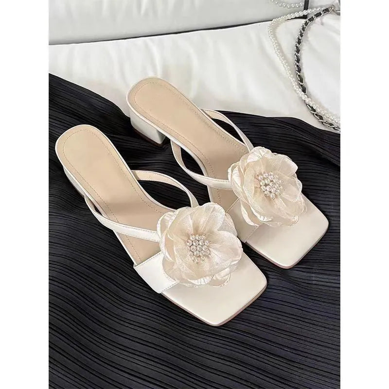 Women's cream-white sandals with chunky heel, square toe, one-line strap, and a decorative flower on the satin upper.