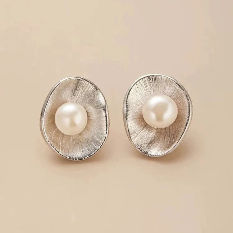 Silver geometric needle earrings with pearl decorative elements on female model