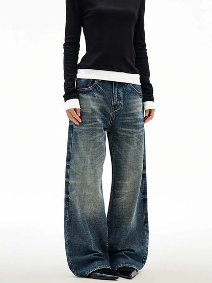 Men's wide leg mid waist jeans in dark blue denim with straight loose cut and distressed cat beard detail