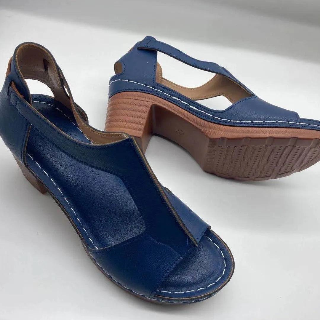 Women's beige peep toe wedge sandals with a buckle strap and low heel on a white background.