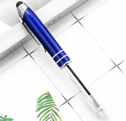 Red metal multifunctional stylus ballpoint pen with LED light on a desk.