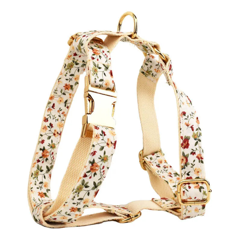 Small white flower decoration on a cloth dog collar and leash set with matching vest and bow.