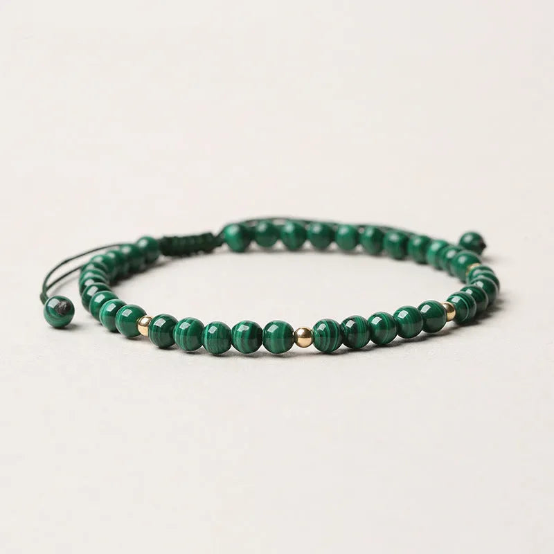 Handwoven green malachite crystal bracelet for women with golden ball accents.