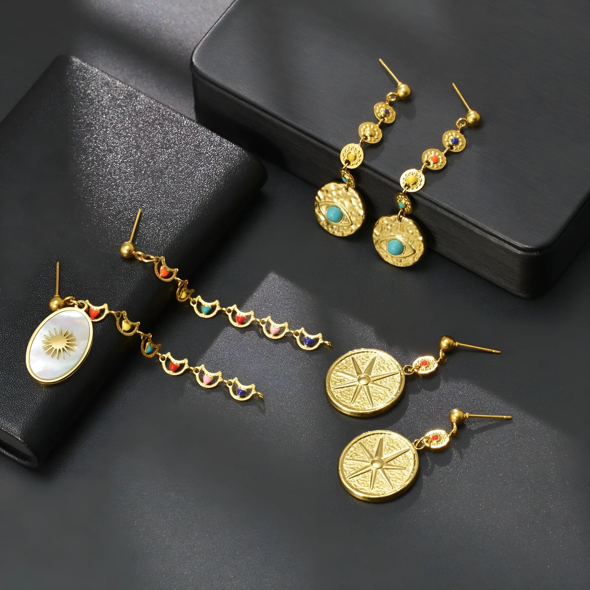 Geometric stainless steel earrings showing Eight Awn Star, Eye and Shell Sun designs