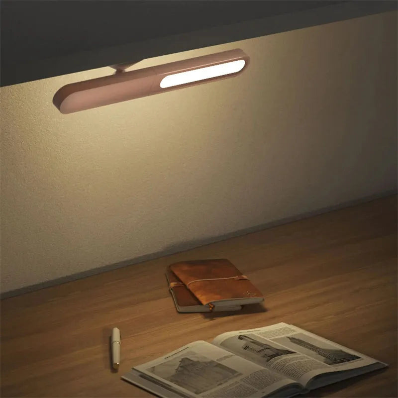 White geometric desk lamp with magnetic base and touch control on a wooden table.