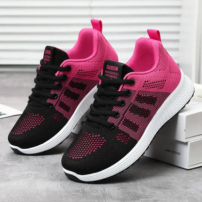 Women's flyknit running shoes in grey pink with soft sole and lace-up front.