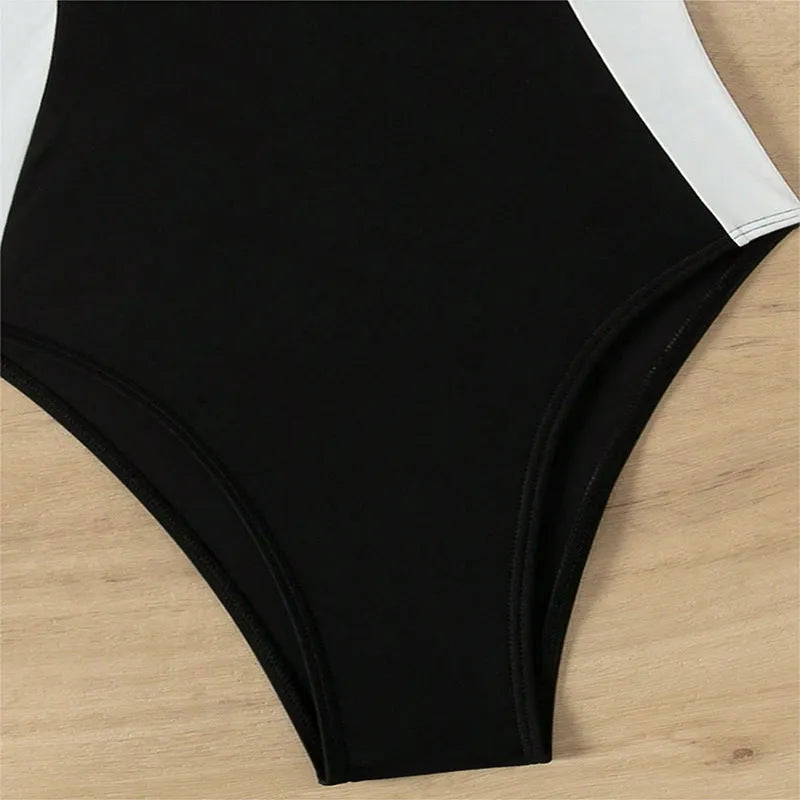 Women's black and white one-piece swimsuit with pearl spaghetti straps and a slimming silhouette.