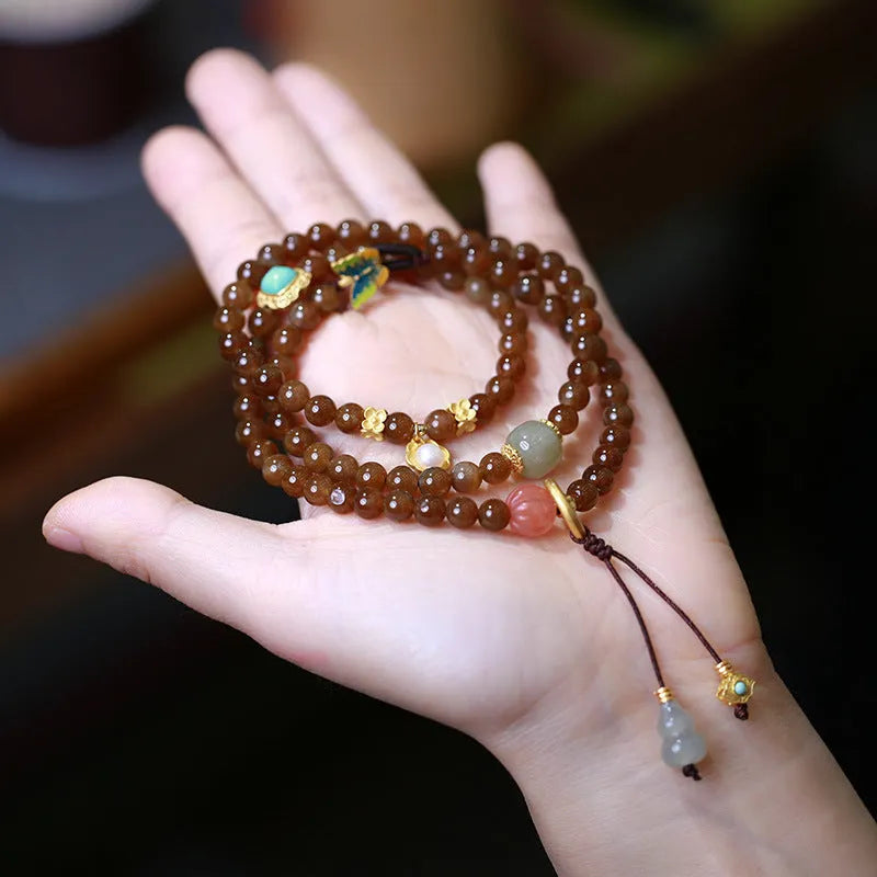 Brown jade women's bracelet with silver butterfly charm and three-ring design.