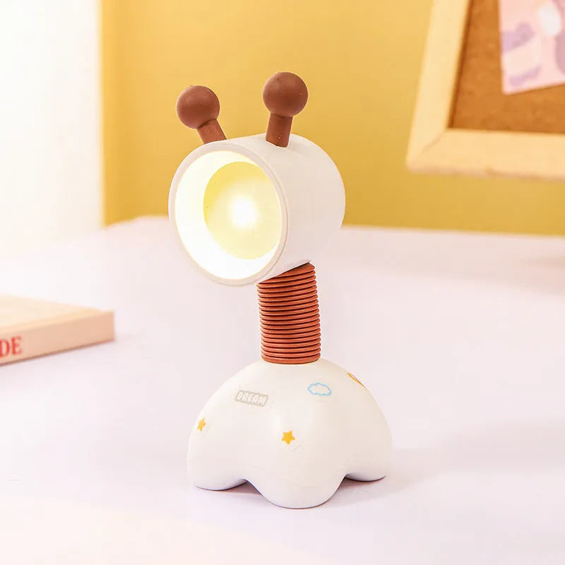 Colourful cartoon character magnetic DIY night light on a desk with adjustable head.