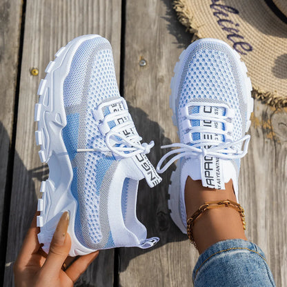 Women's Flyknit mesh lace-up sneaker in a grey colourway showing round toe and rubber sole.